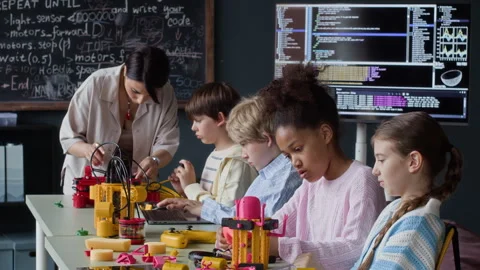 Diverse Children with Female Teacher Constructing Robots in Stem Class Stock Footage 339203737