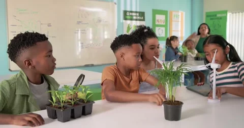 Diverse classmates testing turbines and adjusting blades after tablet update for Stock Footage 337400144