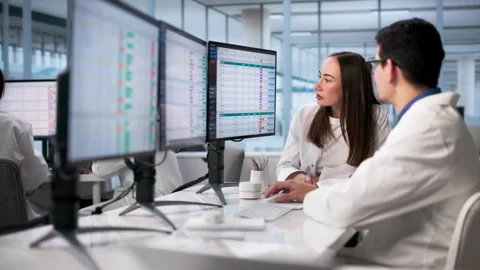 Diverse Clinicians Analyzing Medical Data Using Computers Stock Footage 328392494