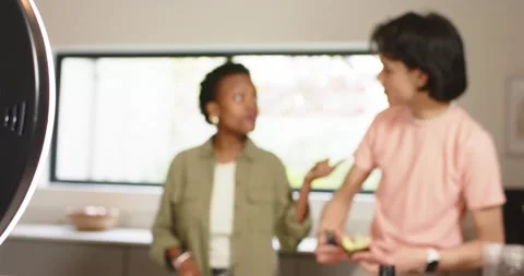 Diverse co-hosts chopping cabbage and scooping avocado on counter under ring Stock-Footage 341467569