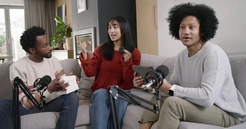 Diverse co-hosts opening white product box, woman presenting small black device Stock Footage 344656670
