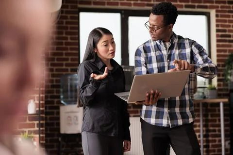 Diverse coders looking at security firewall on laptop Stock Photos