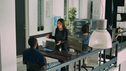 Diverse coders talking about source code on terminal window Stockfoto's