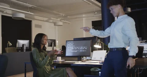 Diverse colleagues collaborating on computer code in modern office during night Stock Footage 315964879
