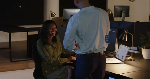 Diverse colleagues collaborating on project, discussing code on computer in Stock Footage 315952939