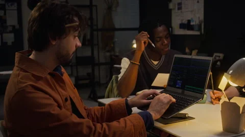 Diverse Colleagues Collaborating on Software Programming Late in Office Stock Footage 338418665