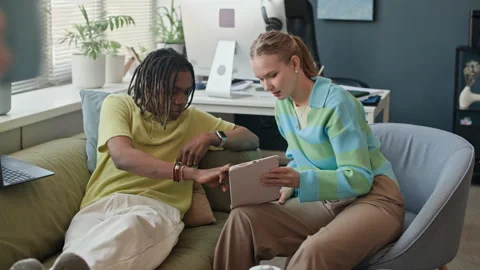 Diverse Colleagues Collaborating on Tablet in Modern Office Stock Footage 338333763