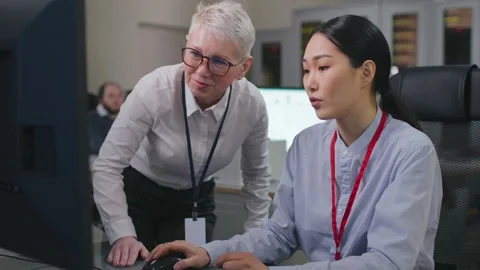 Diverse colleagues discuss data on computer working in modern office Stock Footage 213532589