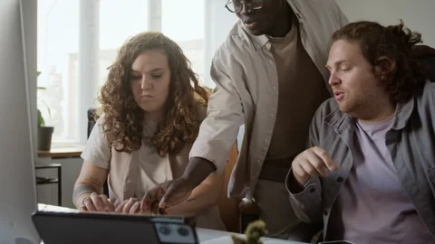 Diverse Colleagues Discussing Project on Computer Screen in Office Stock Footage 348149460