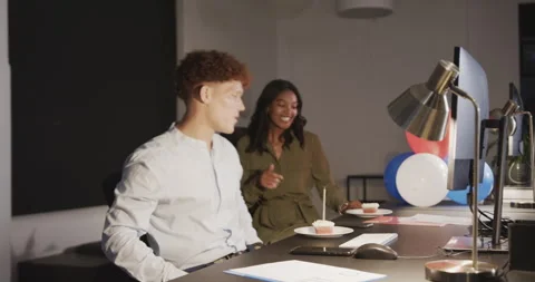 Diverse colleagues discussing work at office desk, smiling and enjoying coffee Stock Footage 315965374