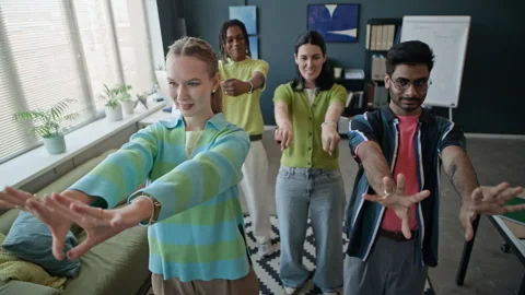 Diverse Colleagues Doing Hand Exercises in Office Stock Footage 338331675