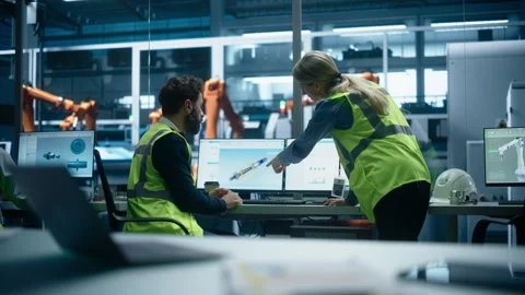 Diverse Colleagues Using Computer At Autonomous Factory Stock Footage 260696515