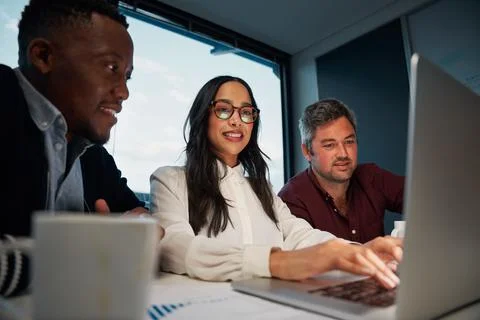 Diverse colleagues using a laptop together at work working on new business Stock Photos