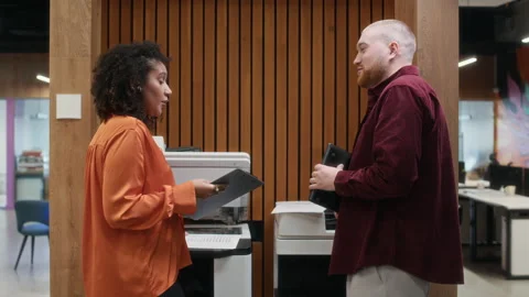 Diverse Colleagues Using Multifunction Printers and Communicating at Office Hall 動画素材 312862779