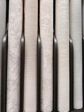 A diverse collection of wallpaper rolls featuring subtle and bold patterns,.. 스톡 사진