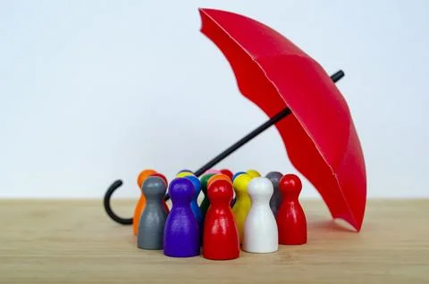 Diverse colorful figures arranged in a collaborative group covered with umb.. Stock Photos