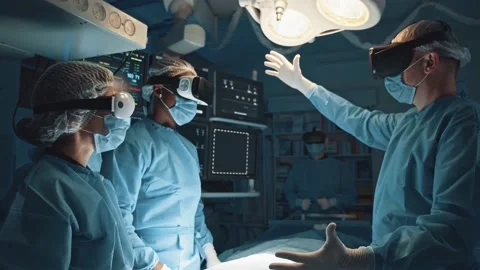 Diverse cooperative surgeon team using VR headsets augmented reality performing Video stock 143680434
