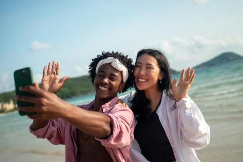 Diverse couple connected, embracing technology and social media while enjoy.. Stock Photos