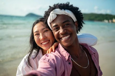 Diverse couple connected, embracing technology and social media while enjoy.. Stock Photos