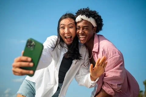 Diverse couple connected, embracing technology and social media while enjoy.. Stock Photos