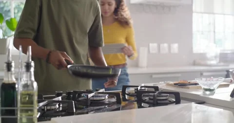 Diverse couple cooking using tablet recipe, man scooping green beans into plate, Stock Footage 337286376