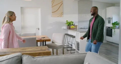 Diverse couple dancing after man gesturing, woman mirroring for bonding at home Stock Footage 342113933