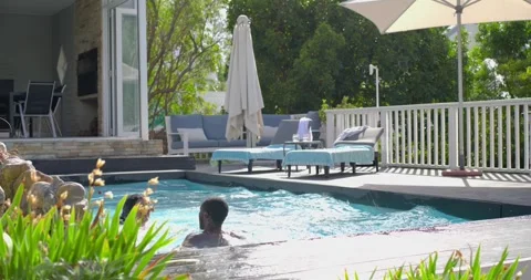 Diverse couple at deck edge blue-suit,pink-trunks jumping, getting float, Stock Footage 341393868
