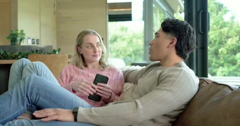 Diverse couple gesturing with controller sharing game tips while listening, Stock Footage 341467446