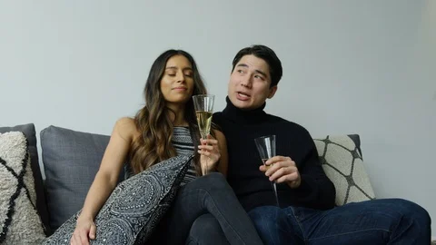 Diverse couple interacting with each other while having champagne in living room Stock Footage 111968033