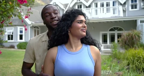 Diverse couple man placing hands on woman sides, wearing hoops, sharing laughter Stock-Footage 345064457