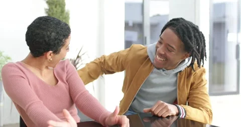 Diverse couple sharing playful hug at table with man approaching after Stock Footage 340393000