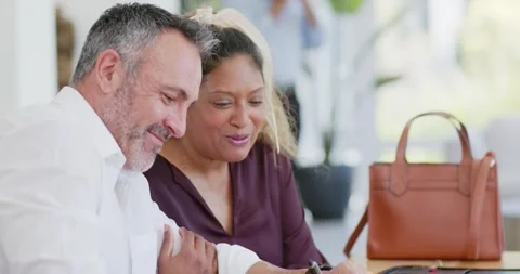 Diverse couple signing documents at office table after review, finalizing forms Stock Footage 344254844