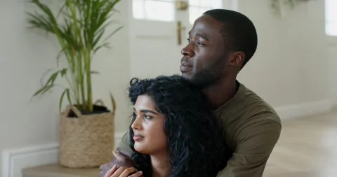 Diverse couple sitting low step man wrapping arms both looking right clasping Stock Footage 341665353