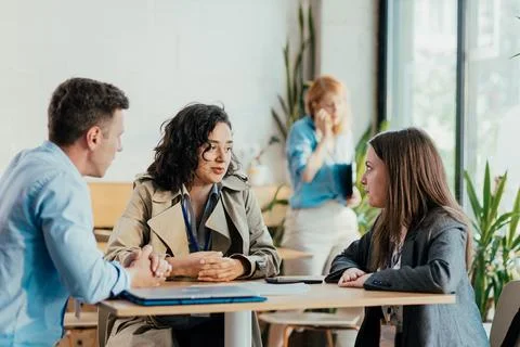 Diverse coworkers collaborating during office coffee break discussion Stock Photos