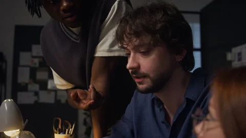 Diverse Coworkers Discussing Project on Computer Screen Late in Office Stock Footage 338415785