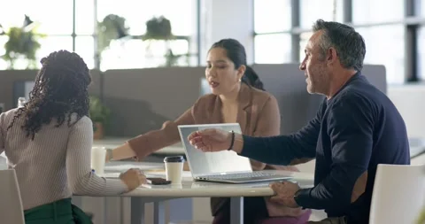 Diverse coworkers exchanging graphs, typing notes, reviewing charts at table Stock Footage 317660705