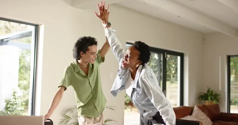 Diverse coworkers exchanging high-five over sticky note covered table in room Stock Footage 339558259