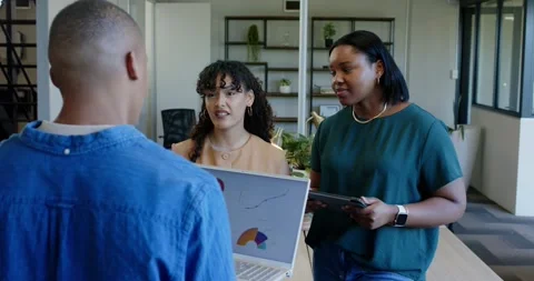 Diverse coworkers presenting data at office table during meeting, referencing Stock Footage 337097562
