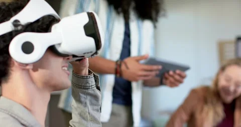 Diverse coworkers tapping tablet data and testing white VR headset at office Stock Footage 336535529