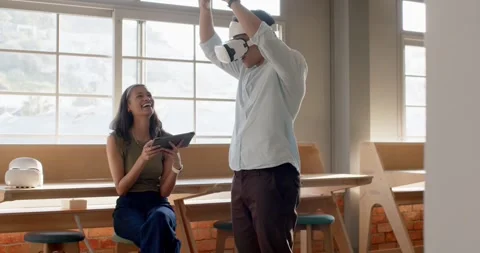 Diverse coworkers testing VR demo after man putting on headset, woman operating Stock Footage 339983490