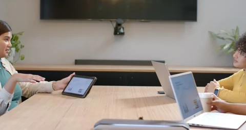 Diverse coworkers watching presenter tapping tablet coming in from left Stock Footage 344964032