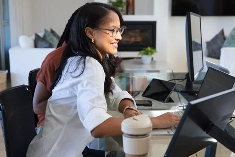 Diverse coworkers working together using laptop and external monitors in modern Stock Photos