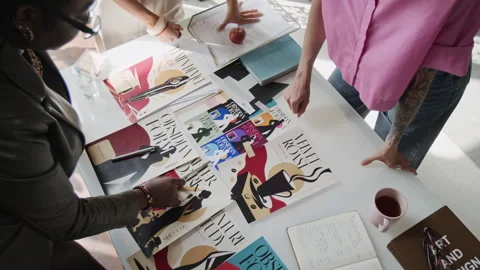 Diverse Creative Team Reviewing Graphic Design Layouts in Studio Stock Footage 345819873
