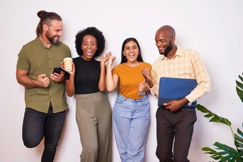 Diverse creative tech team lean against wall and celebrates success, cheer smile Stock Photos