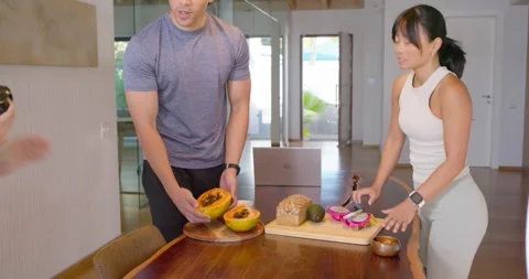 Diverse crew checking framing, stylist placing papayas on kitchen table, 스톡 동영상 335212590