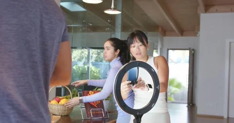 Diverse crew prepping at kitchen table, arranging fruit basket, placing ring 스톡 동영상 335906971