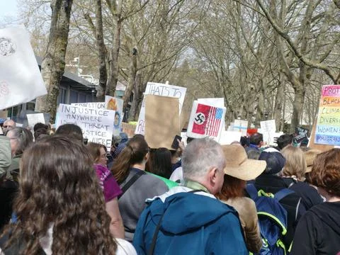 Diverse crowd marching together for various social causes, holding signs an.. Stock Photos