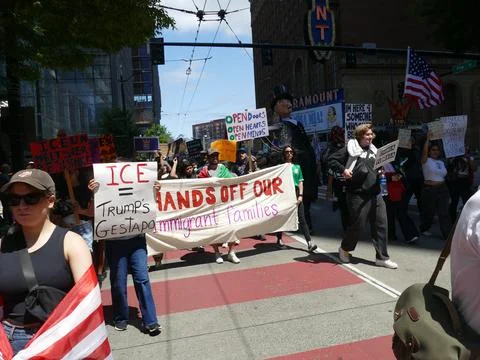 Diverse crowd protesting against ICE family separations, holding colorful s.. Stock Photos