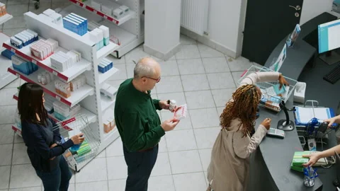 Diverse customers waiting in line to pay for drugs or pills at pharmacy shop Stock Footage 219434683