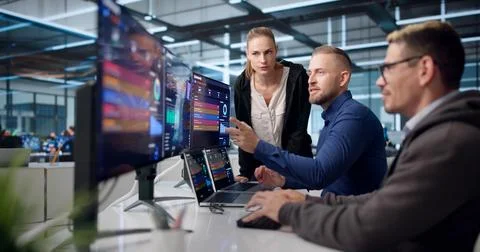 Diverse Cybersecurity Team Analyzes Data On Laptops To Protect Networks. Stockfoto's